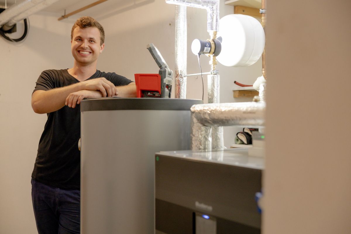 Handwerker vor Wärmespeicher einer Wärmepumpe