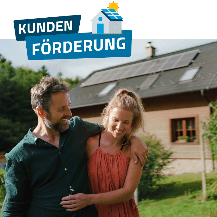 Paar vor einem Haus mit Solaranlage auf dem Dach, Symbolbild für Förderung von Photovoltaikanlagen.